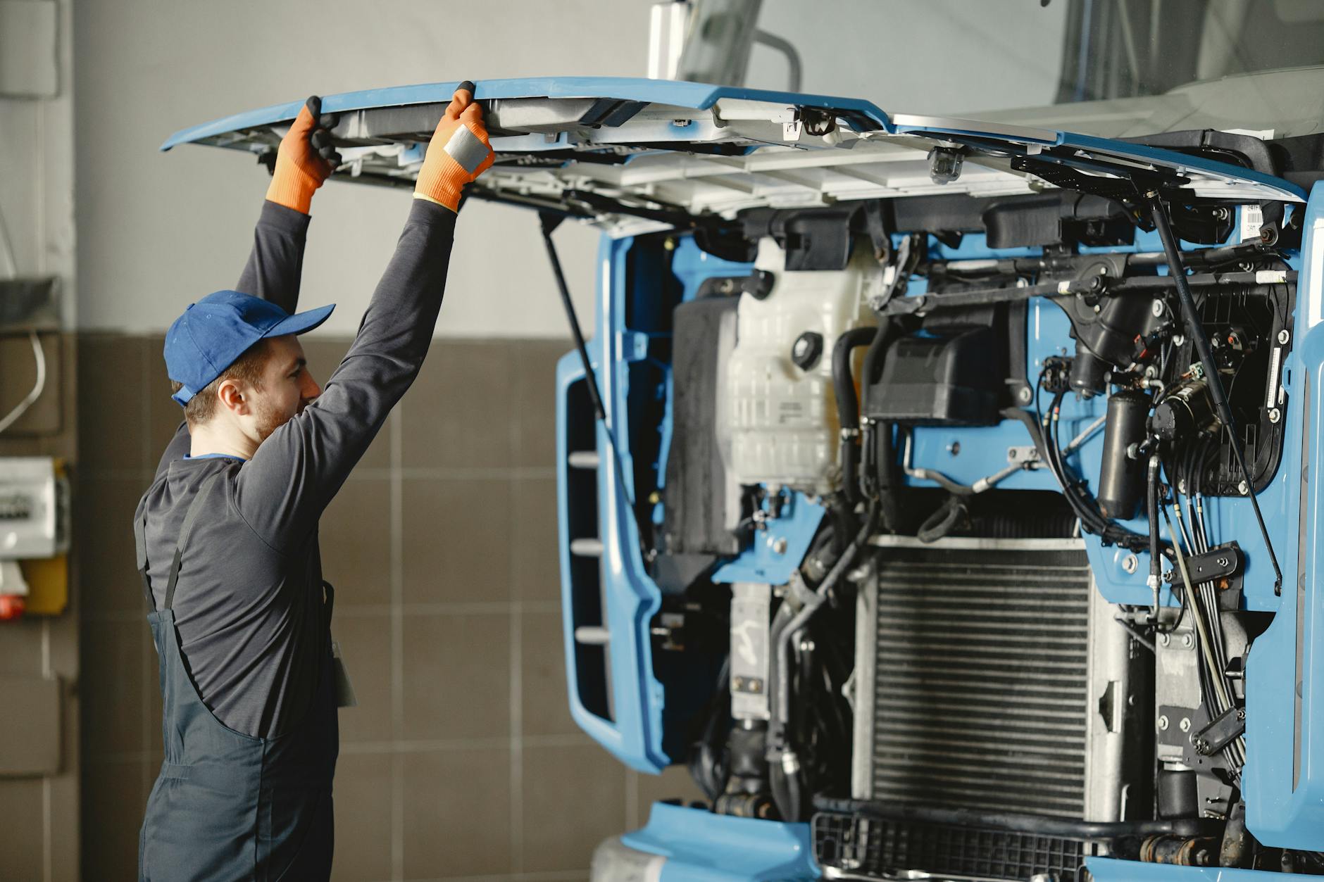 Mechanik w hali serwisowej sprawdza silnik ciężarówki
