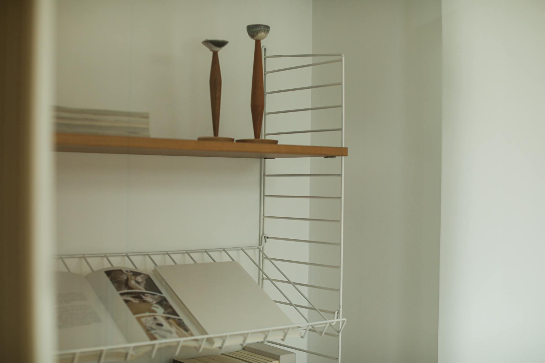 Minimalistyczna półka z otwartą książką i świecznikami w stylu modernistycznym