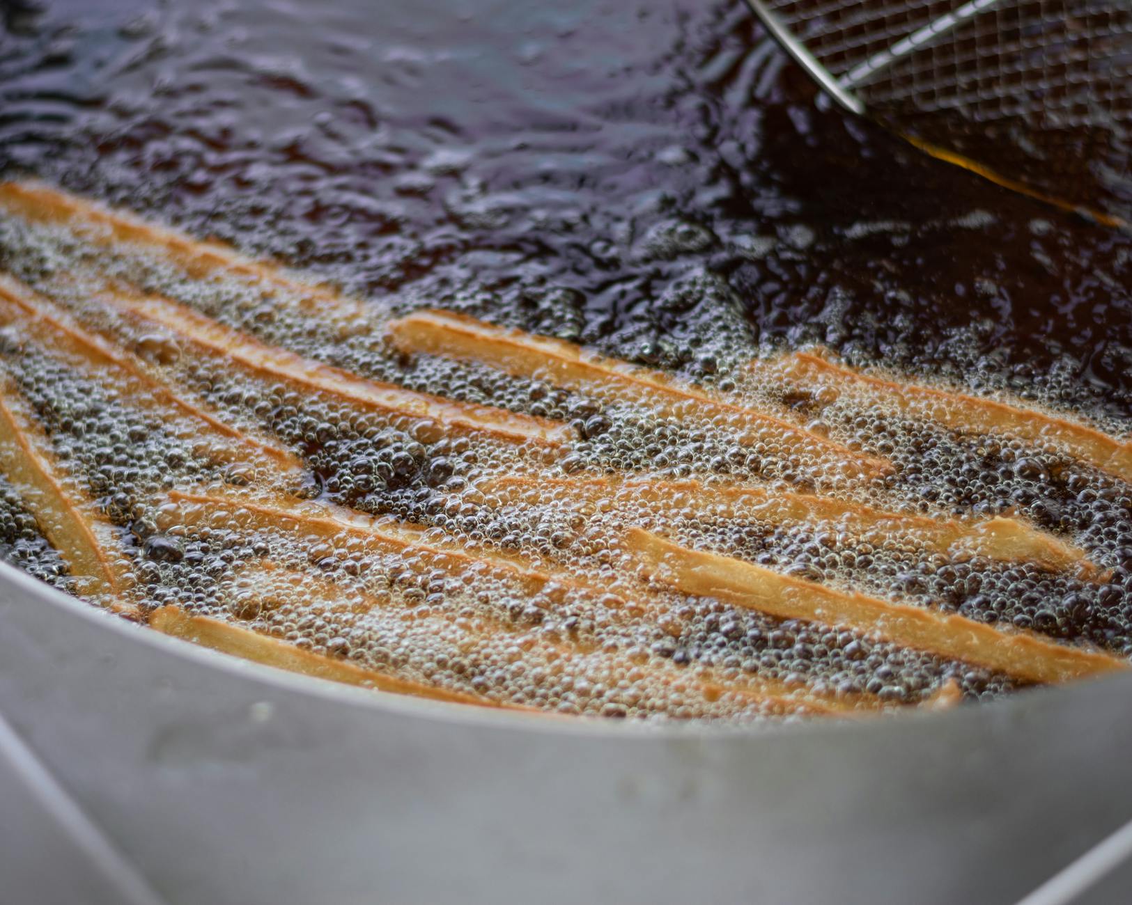 Frytki smażone w głębokim oleju w gastronomicznej frytownicy