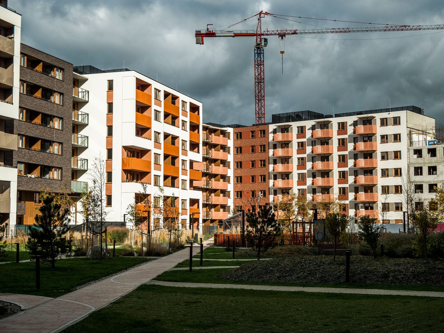 Nowe bloki mieszkalne w Gdyni z żurawiem budowlanym na tle chmur